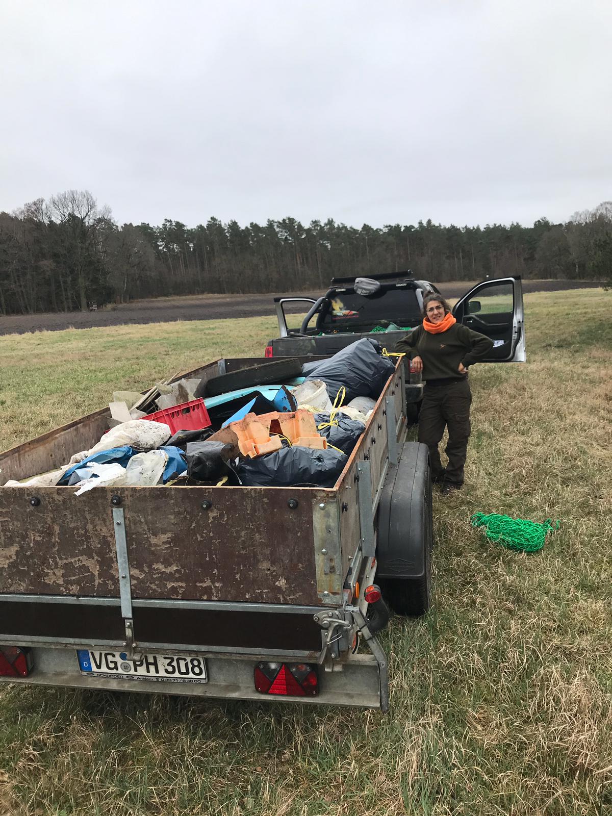 Jäger befüllen Container mit Müll aus dem Wald